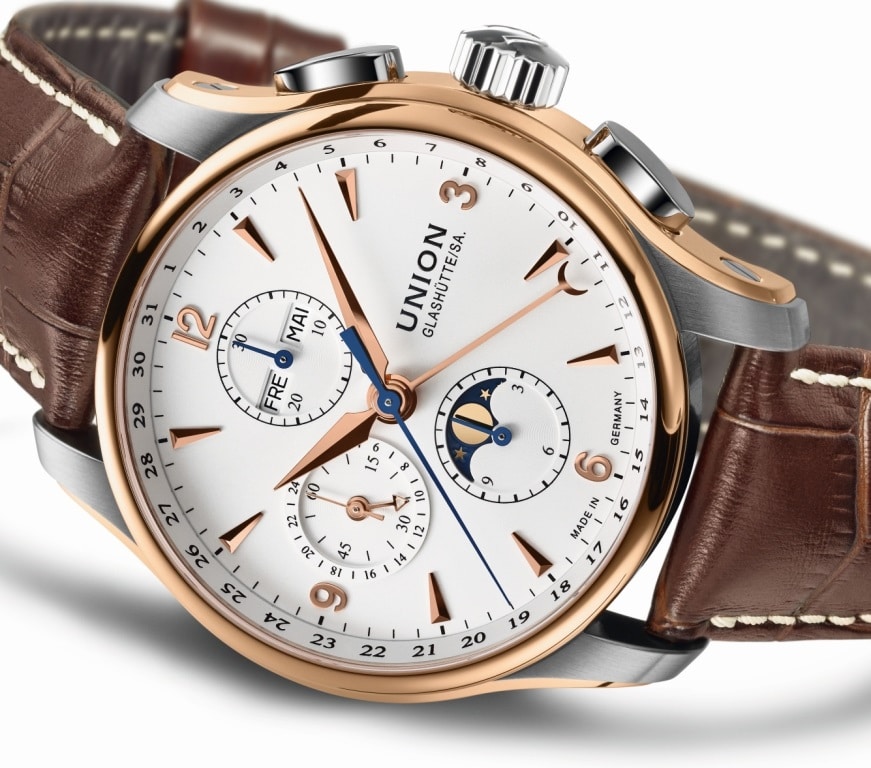 Von Union Glashütte kommt der Belisar Chronographe Mondphase als edle Bicolor-Variante in einer besonders hochwertigen Bicolor-Ausführung: Die Lünette und die charakteristischen aufgeschraubten Flanken sind aus 18-karätigem Roségold gefertigt.